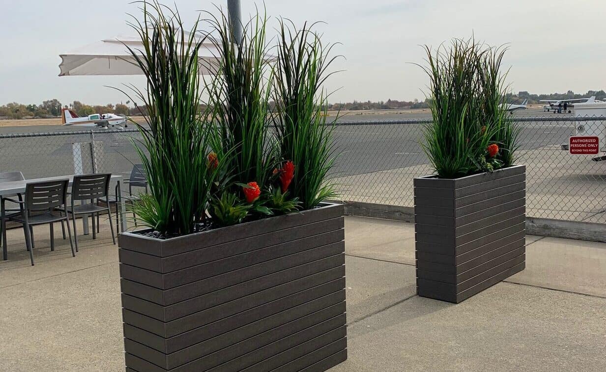 Outdoor barrier using artificial grasses